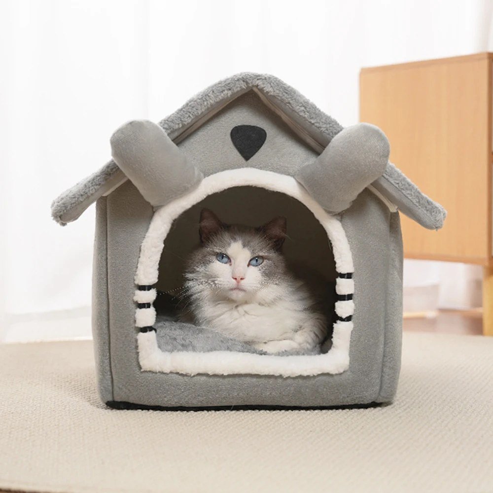 Ragdoll cat lying in the doorway of the grey cat house bed