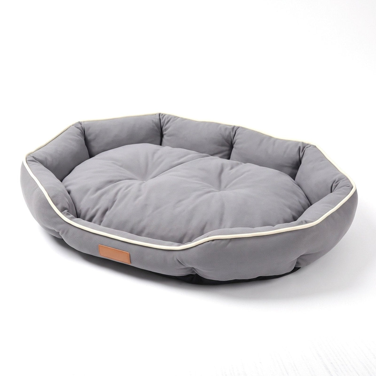 Oval bolster sofa dog bed in Grey with cream piping, on a white background